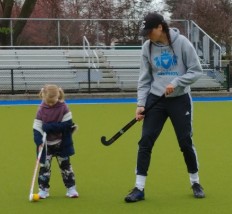 Child learning to play field hockey